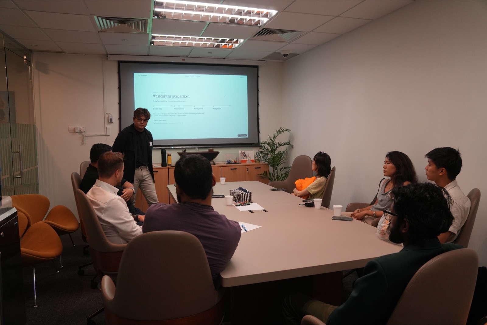Workshop participants listening during a group debrief on what each group noticed